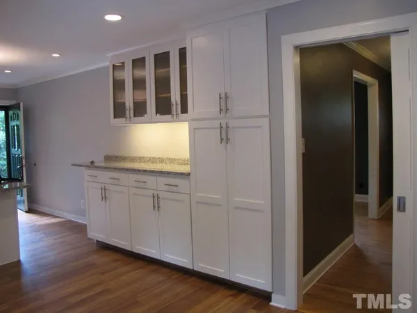 an empty room with wooden floor and cabinet