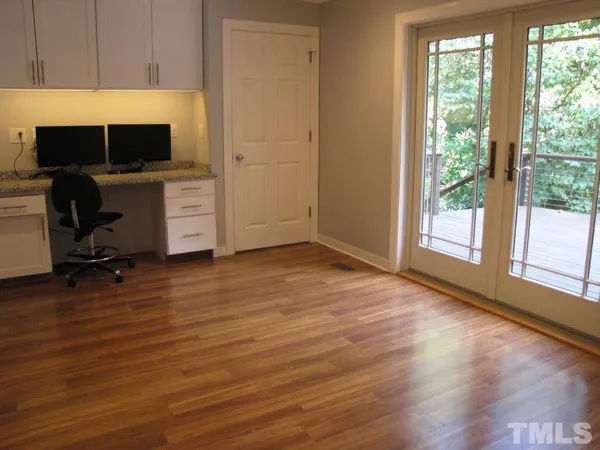 a view of a workspace with wooden floor and a window