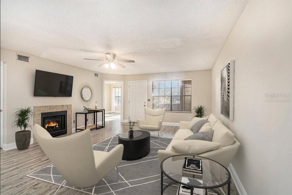315 Lakepointe Drive, Unit 104 Altamonte Springs, FL 32701 - Photo 3 of 20 a living room with furniture a flat screen tv and a fireplace