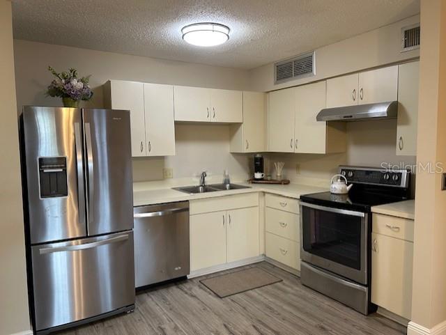 315 Lakepointe Drive, Unit 104 Altamonte Springs, FL 32701 - Photo 6 of 20 a kitchen with stainless steel appliances a refrigerator stove and white cabinets