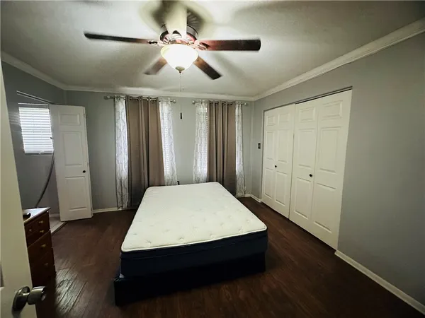a room with wooden floor and ceiling fan