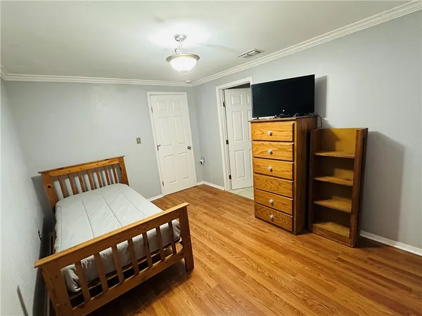 a bedroom with a bed and wooden floor
