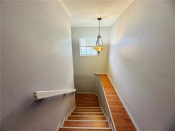a view of a hallway with wooden floor and staircase