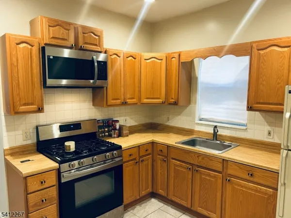 a kitchen with stainless steel appliances a stove a sink and a microwave