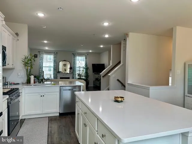 a kitchen with a sink a chandelier and living room view