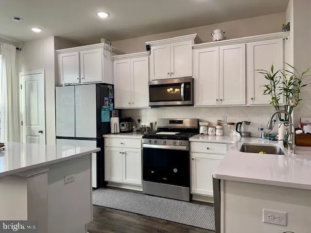 a kitchen with stainless steel appliances granite countertop a stove a sink and a refrigerator