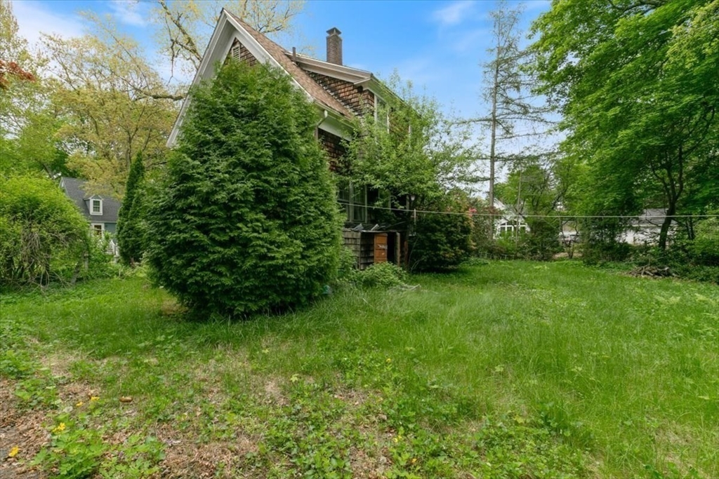 42 Maple Street Hamilton, MA 01982 - Photo 12 of 18 a view of a backyard with potted plants and large trees