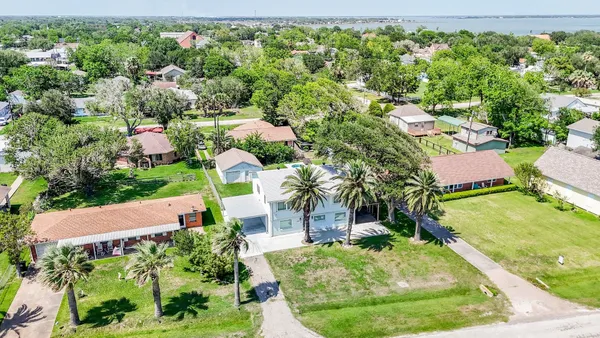 an aerial view of residential houses with outdoor space and trees