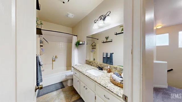 a bathroom with a granite countertop sink mirror vanity and bathtub