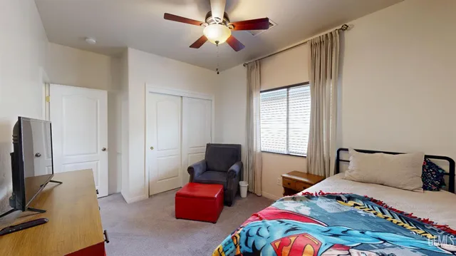 a bedroom that has a bed and a flat screen tv