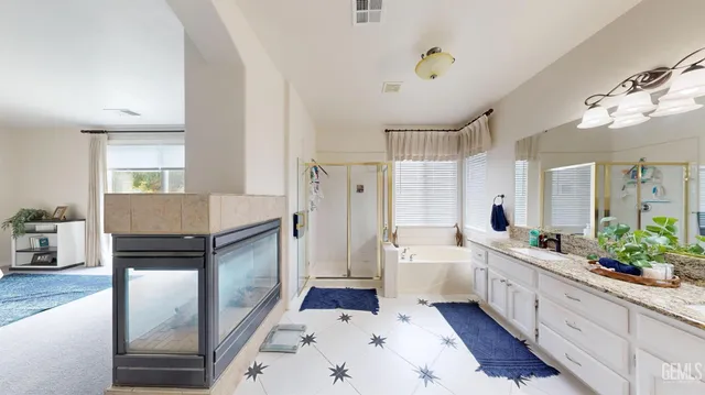a large bathroom with a double vanity sink a large mirror a bathtub and a shower