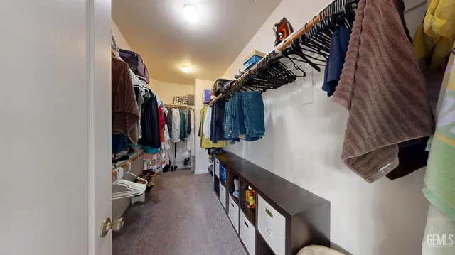 a view of walk in closet with clothes and shoes