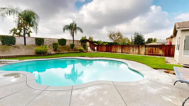 a swimming pool with outdoor seating and barbeque oven