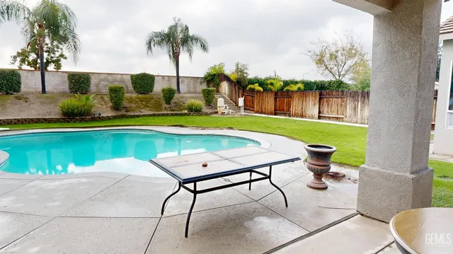 a view of a swimming pool with a patio and a garden