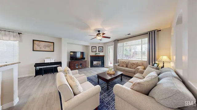 a living room with furniture a large window and a fireplace