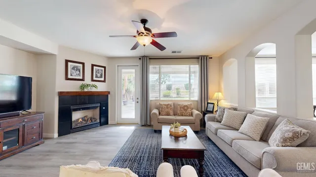 a living room with furniture a fireplace and a flat screen tv