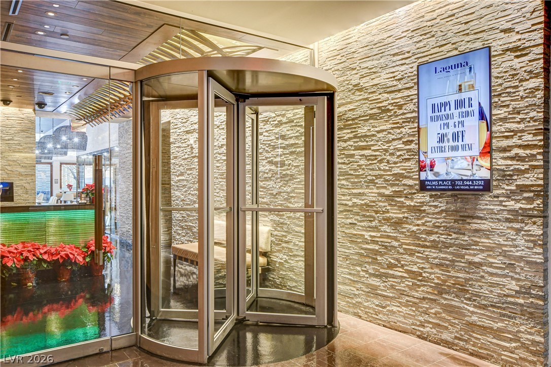 4381 West Flamingo Road, Unit 3002 Las Vegas, NV 89103 - Photo 29 of 59 A grand revolving glass door introduces an entry accented by textured stone walls.