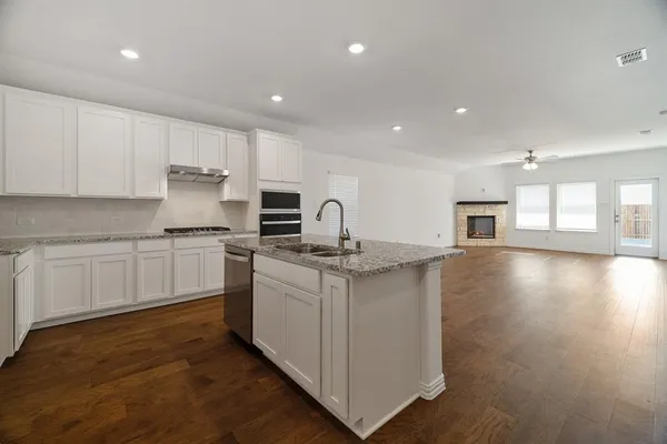 a view of empty room with wooden floor and ceiling fan