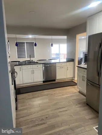 a kitchen with stainless steel appliances granite countertop a refrigerator a stove a sink and a microwave