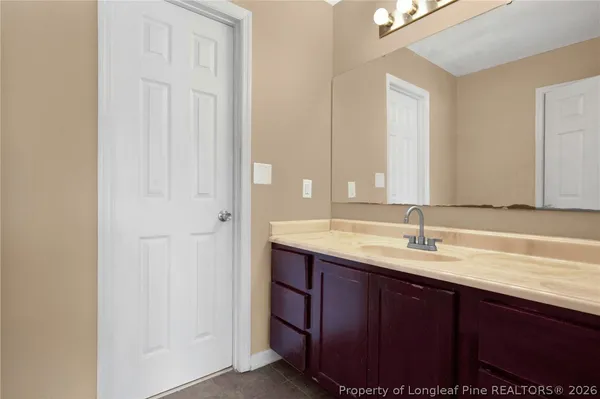 a bathroom with a granite countertop sink and a mirror