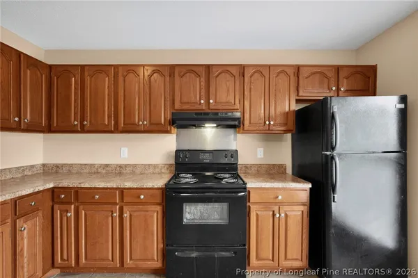 a kitchen with granite countertop cabinets and refrigerator