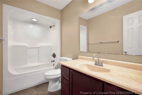 a bathroom with a sink a toilet and a large mirror