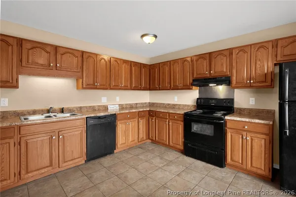 a kitchen with granite countertop a stove sink and cabinets