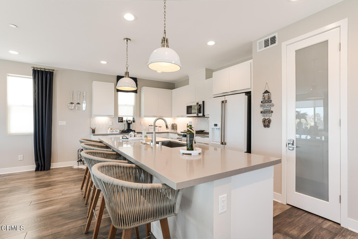 1028 Harbor Boulevard Oxnard, CA 93035 - Photo 20 of 48 a kitchen with stainless steel appliances kitchen island granite countertop a refrigerator a sink a stove and white cabinets with wooden floor
