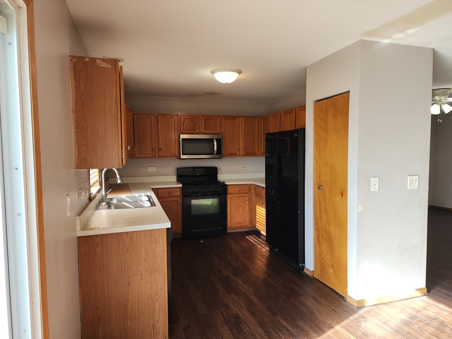 5216 Riviera Boulevard Plainfield, IL 60586 - Photo 5 of 14 a kitchen with a refrigerator sink and wooden floor