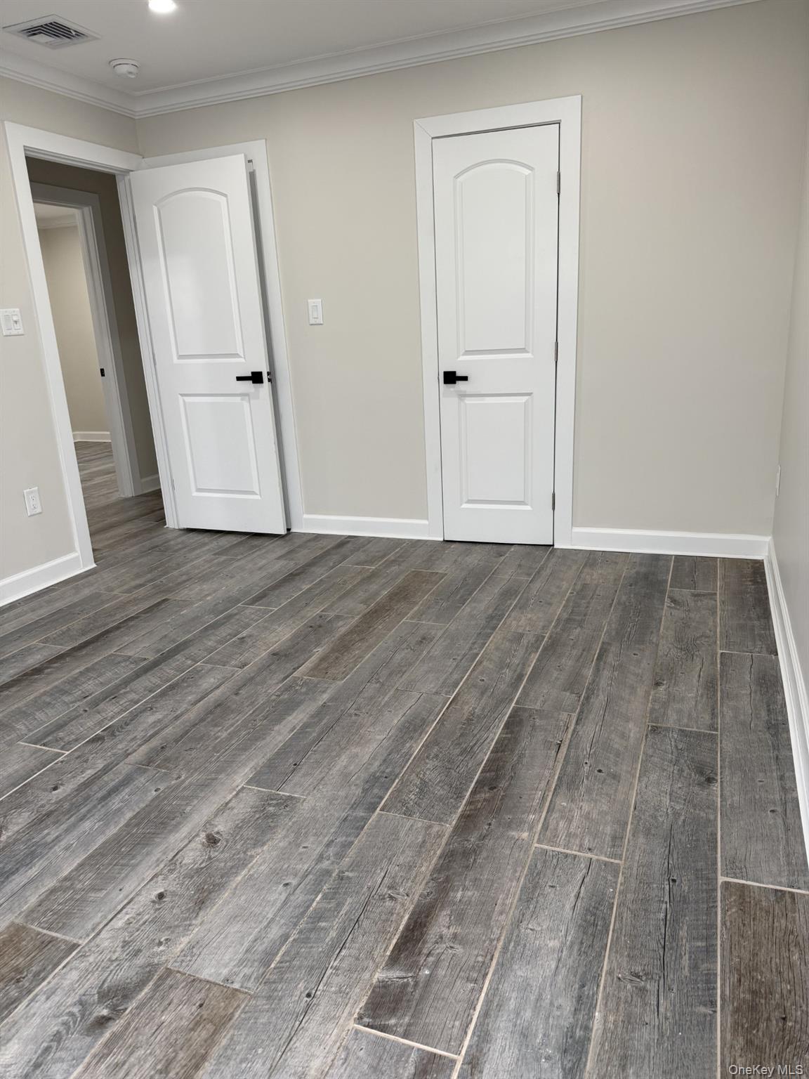 11 Bayview Avenue Lawrence, NY 11559 - Photo 12 of 18 a view of a room with wooden floor and white doors