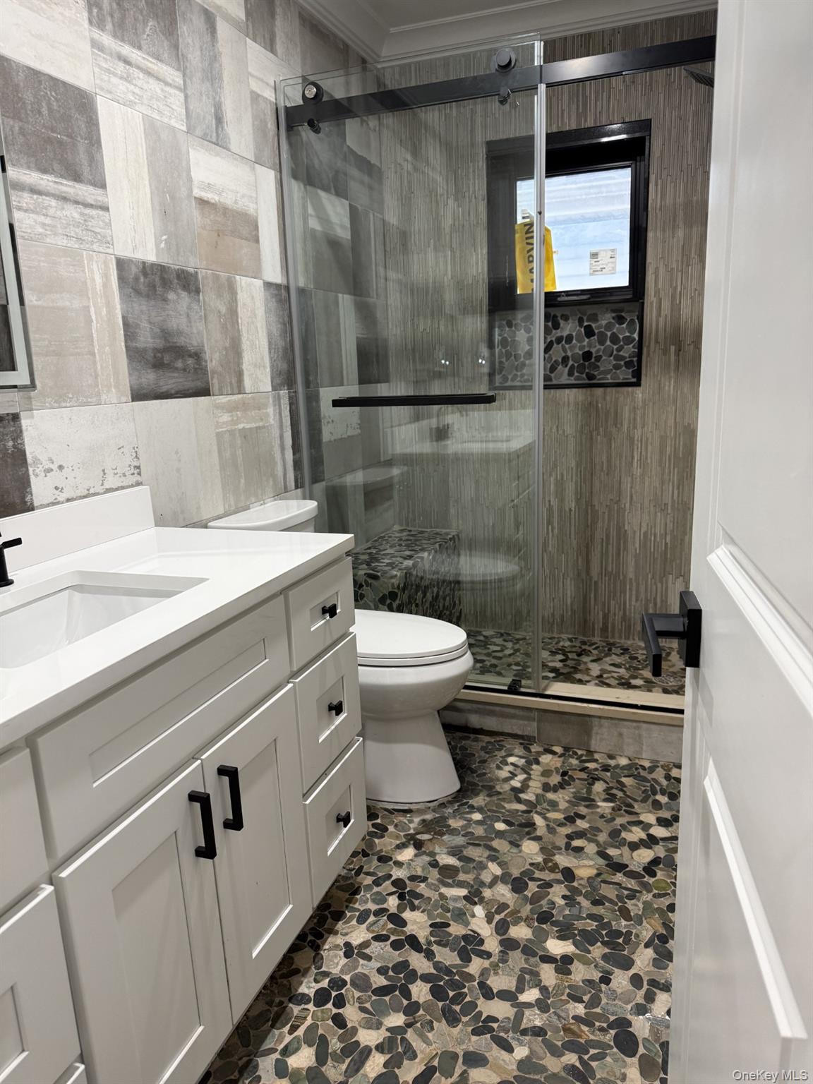 11 Bayview Avenue Lawrence, NY 11559 - Photo 15 of 18 a bathroom with a sink a toilet and shower