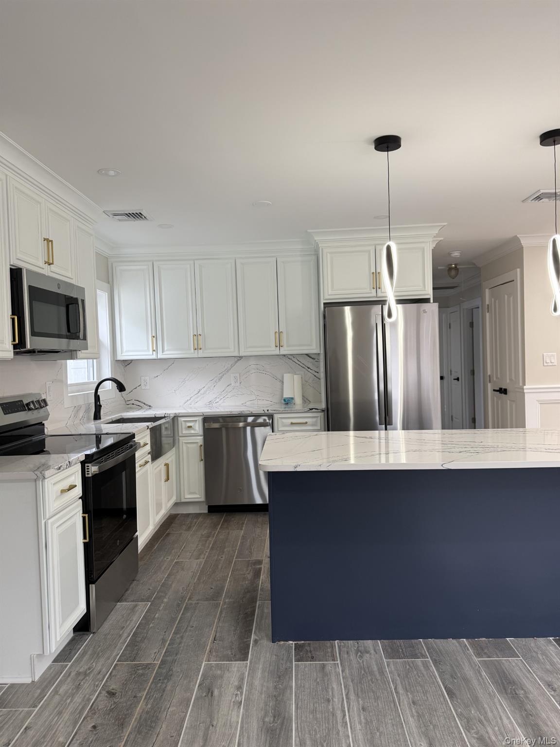 11 Bayview Avenue Lawrence, NY 11559 - Photo 6 of 18 a kitchen with granite countertop a sink a counter space appliances and cabinets
