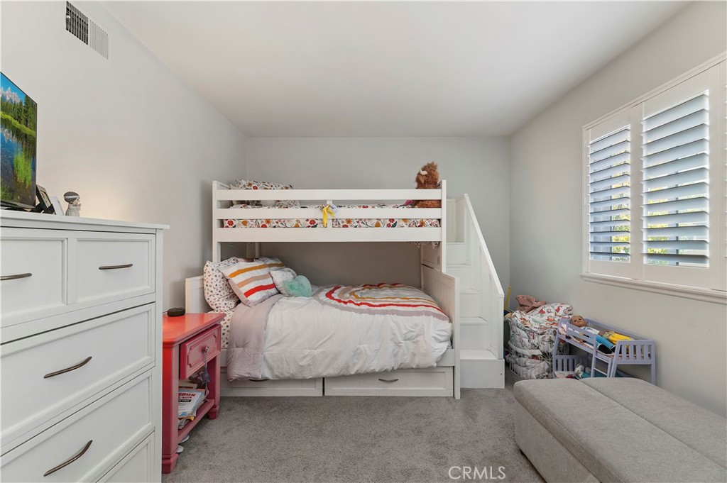 16406 Vista Roma Circle, Unit 115 Huntington Beach, CA 92649 - Photo 13 of 26 a bedroom with a bed and a dresser