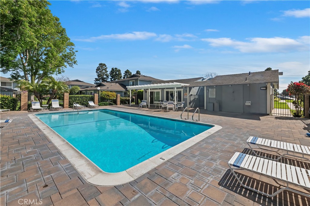 16406 Vista Roma Circle, Unit 115 Huntington Beach, CA 92649 - Photo 23 of 26 a view of a swimming pool with lawn chairs and a barbeque