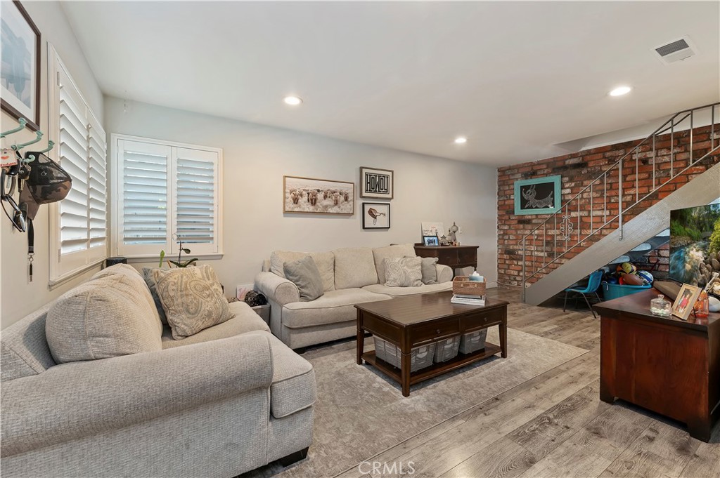 16406 Vista Roma Circle, Unit 115 Huntington Beach, CA 92649 - Photo 4 of 26 a living room with furniture and stairs