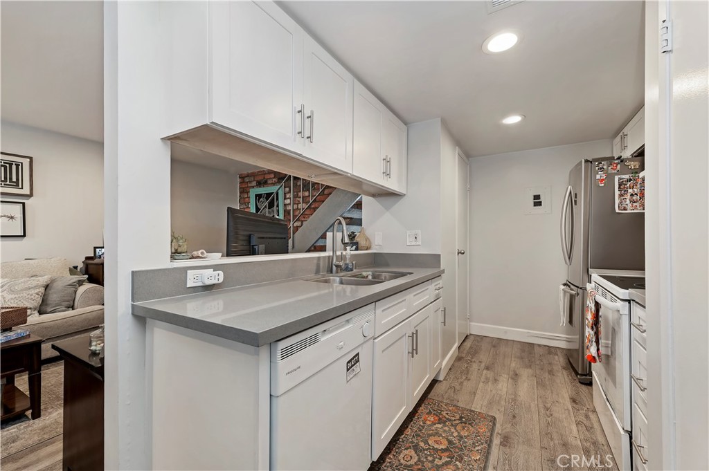 16406 Vista Roma Circle, Unit 115 Huntington Beach, CA 92649 - Photo 5 of 26 a kitchen with a sink stove and refrigerator