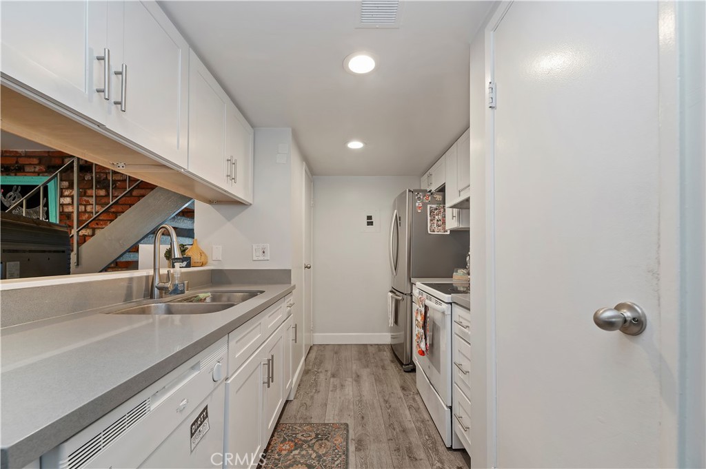 16406 Vista Roma Circle, Unit 115 Huntington Beach, CA 92649 - Photo 7 of 26 a kitchen with refrigerator cabinets and a sink