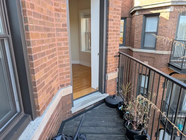 a view of a porch with wooden floor and a gate