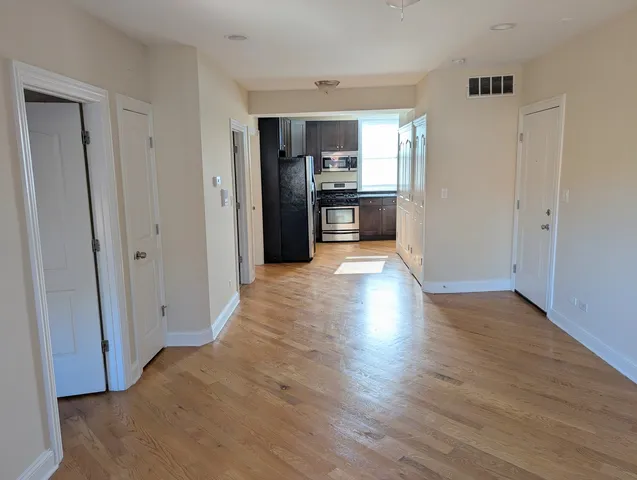 a view of a kitchen with wooden floor and a refrigerator