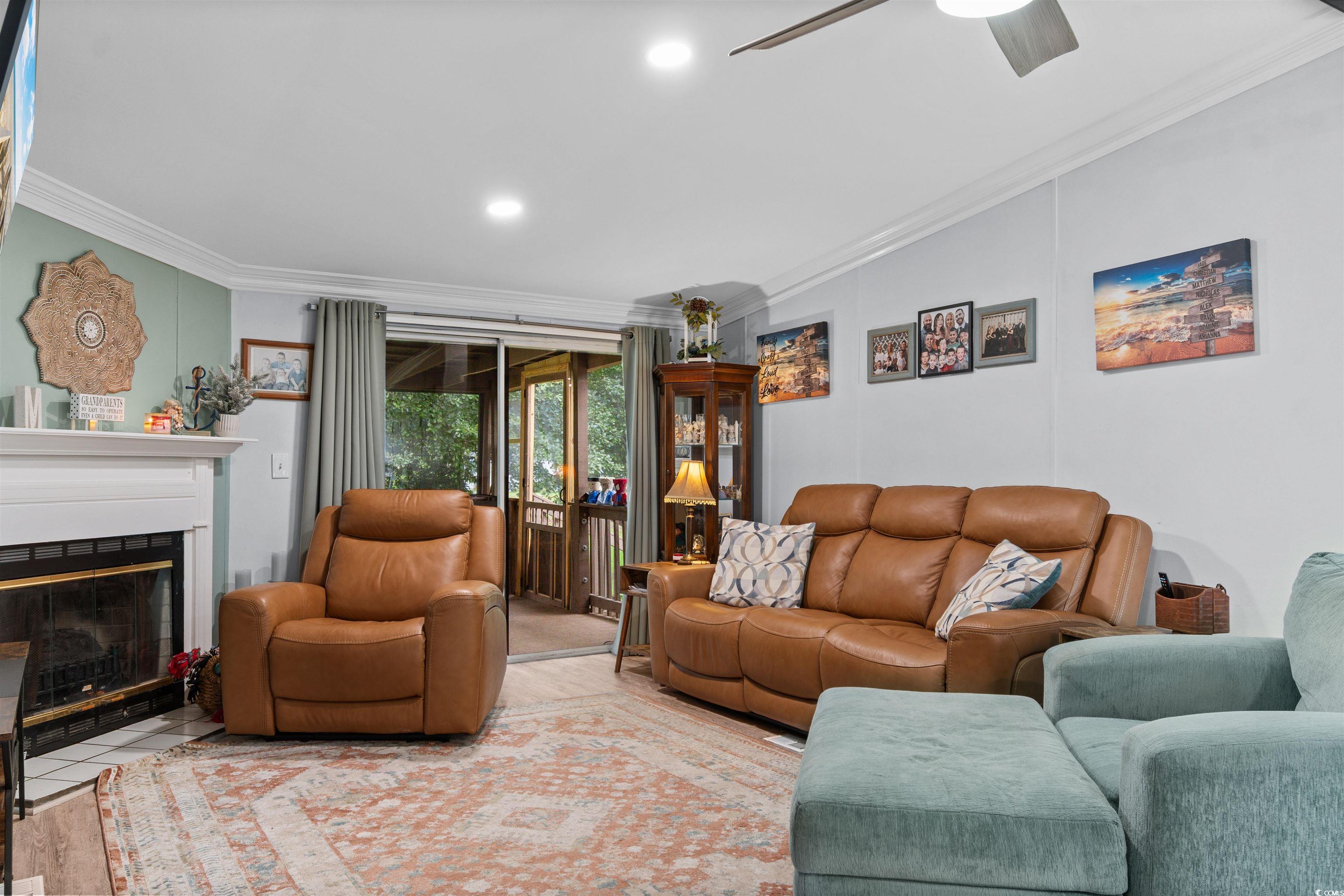 11140 Mcdowell Shortcut Road Murrells Inlet, SC 29576 - Photo 12 of 33 Living room with crown molding, a fireplace with flush hearth, and ceiling fan