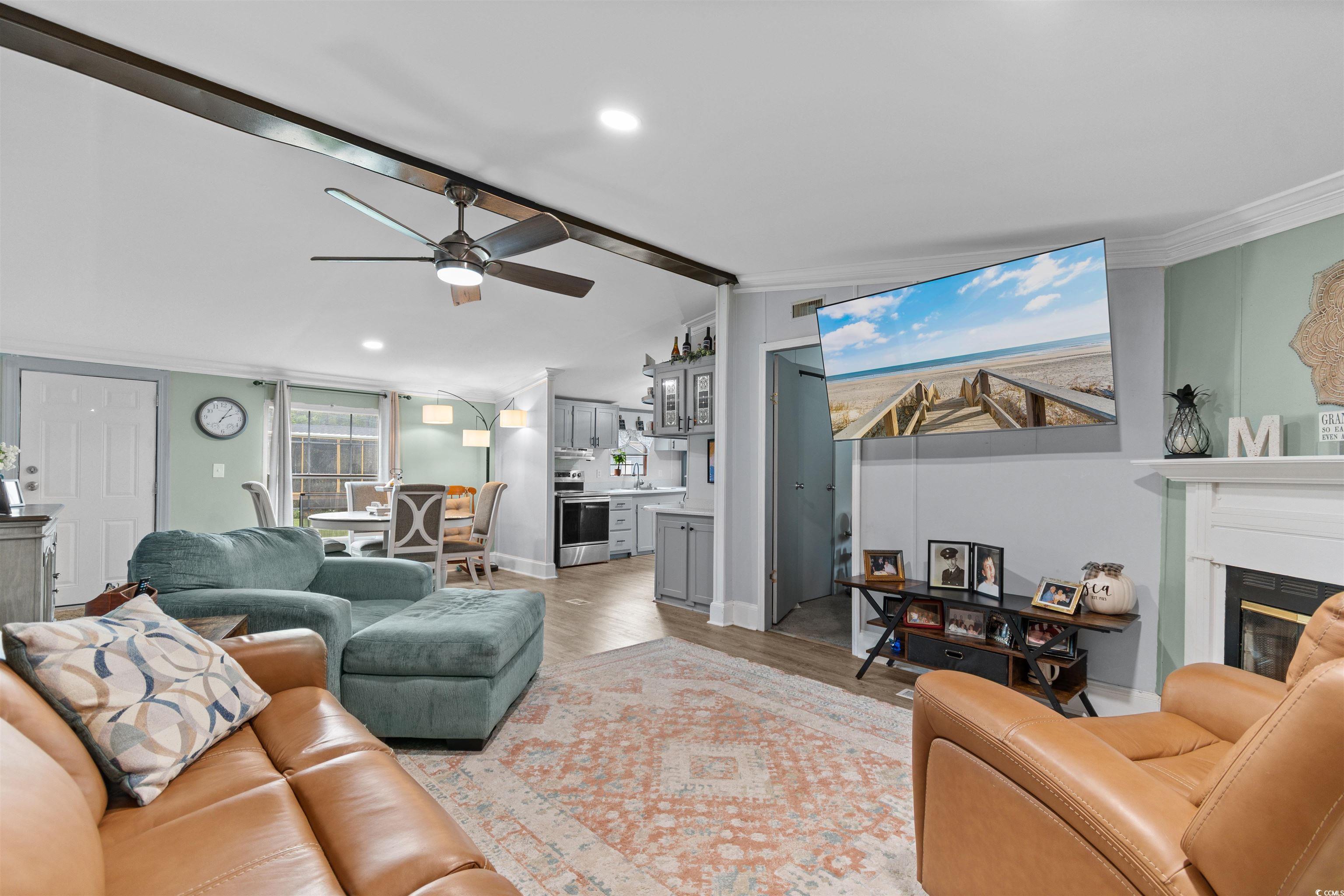 11140 Mcdowell Shortcut Road Murrells Inlet, SC 29576 - Photo 13 of 33 Living room featuring light wood finished floors, crown molding, recessed lighting, a glass covered fireplace, and ceiling fan