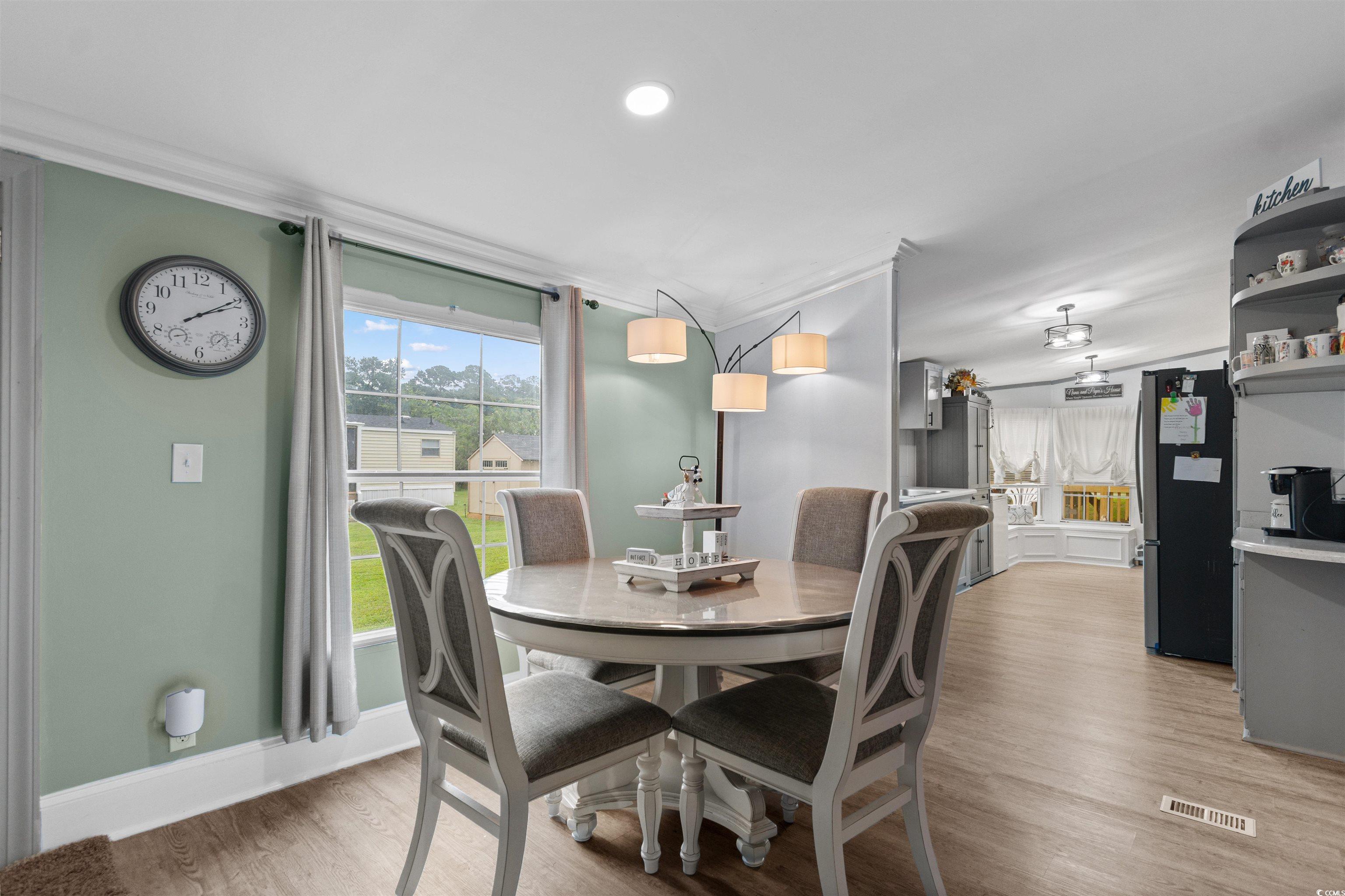 11140 Mcdowell Shortcut Road Murrells Inlet, SC 29576 - Photo 15 of 33 Dining area featuring crown molding and light wood-style floors