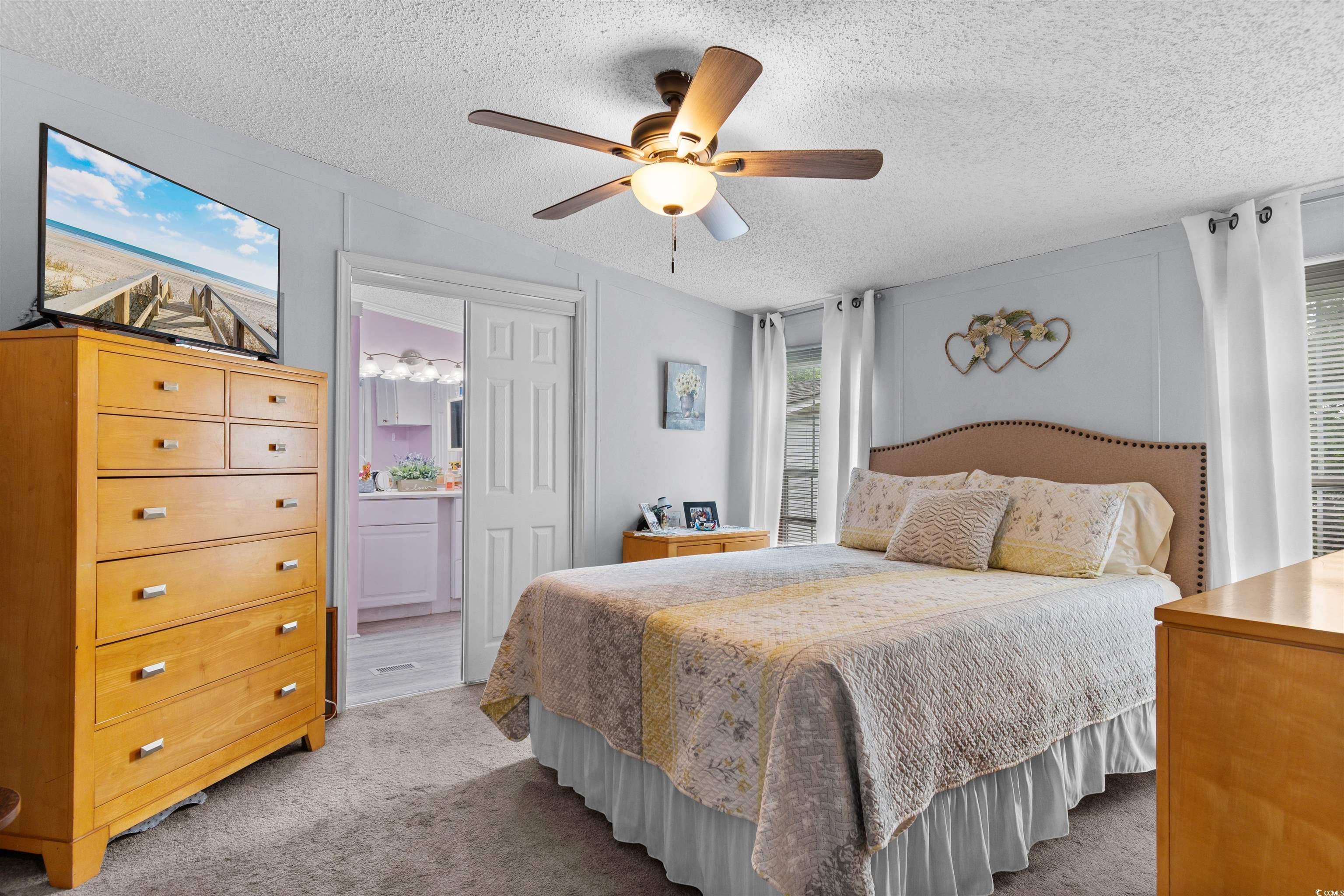 11140 Mcdowell Shortcut Road Murrells Inlet, SC 29576 - Photo 16 of 33 Carpeted bedroom featuring a textured ceiling, ceiling fan, and ensuite bathroom