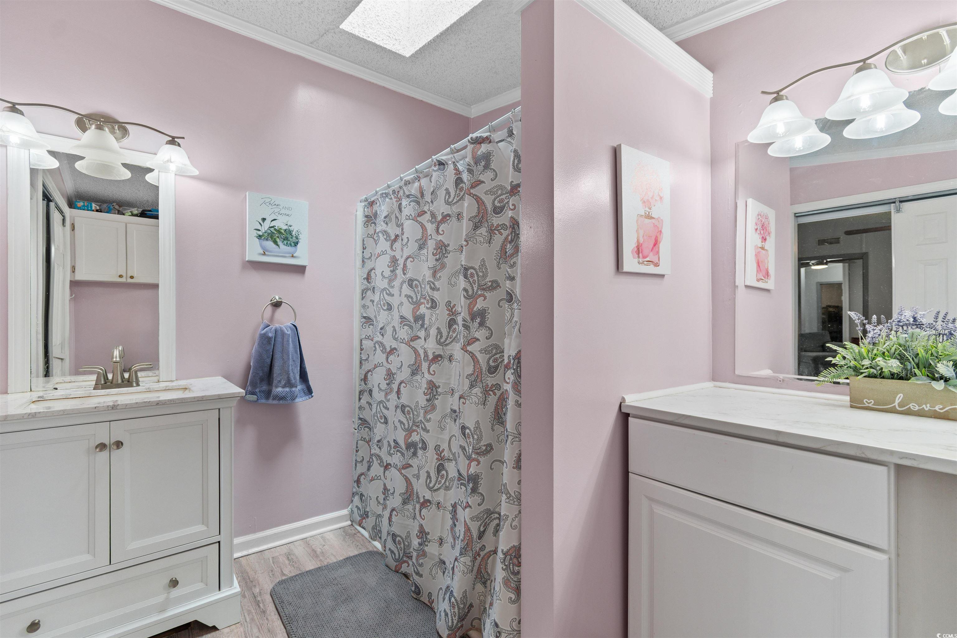11140 Mcdowell Shortcut Road Murrells Inlet, SC 29576 - Photo 18 of 33 Full bath featuring ornamental molding, vanity, wood finished floors, a skylight, and a chandelier