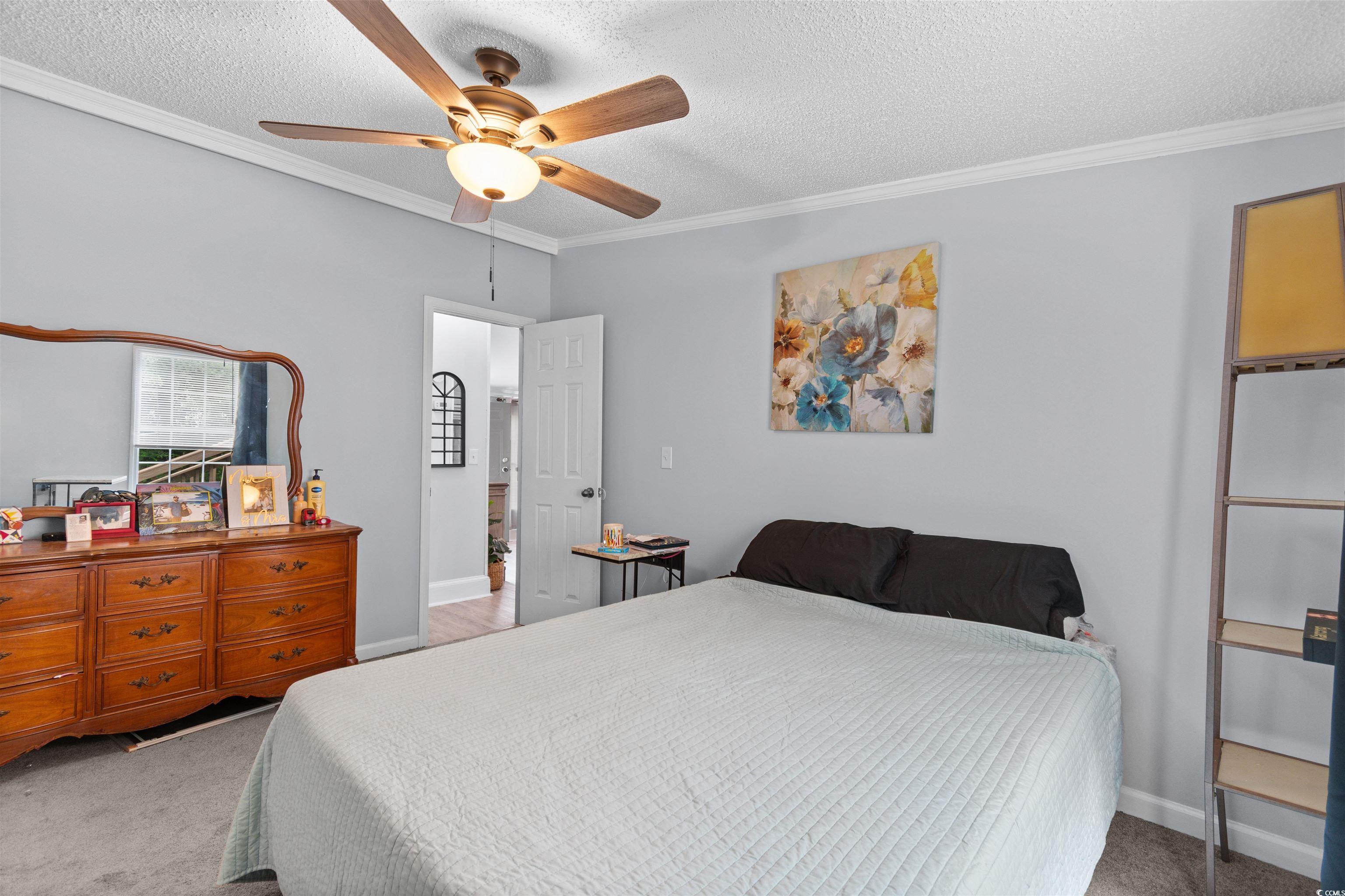 11140 Mcdowell Shortcut Road Murrells Inlet, SC 29576 - Photo 21 of 33 Bedroom featuring ornamental molding, carpet floors, a textured ceiling, and a ceiling fan