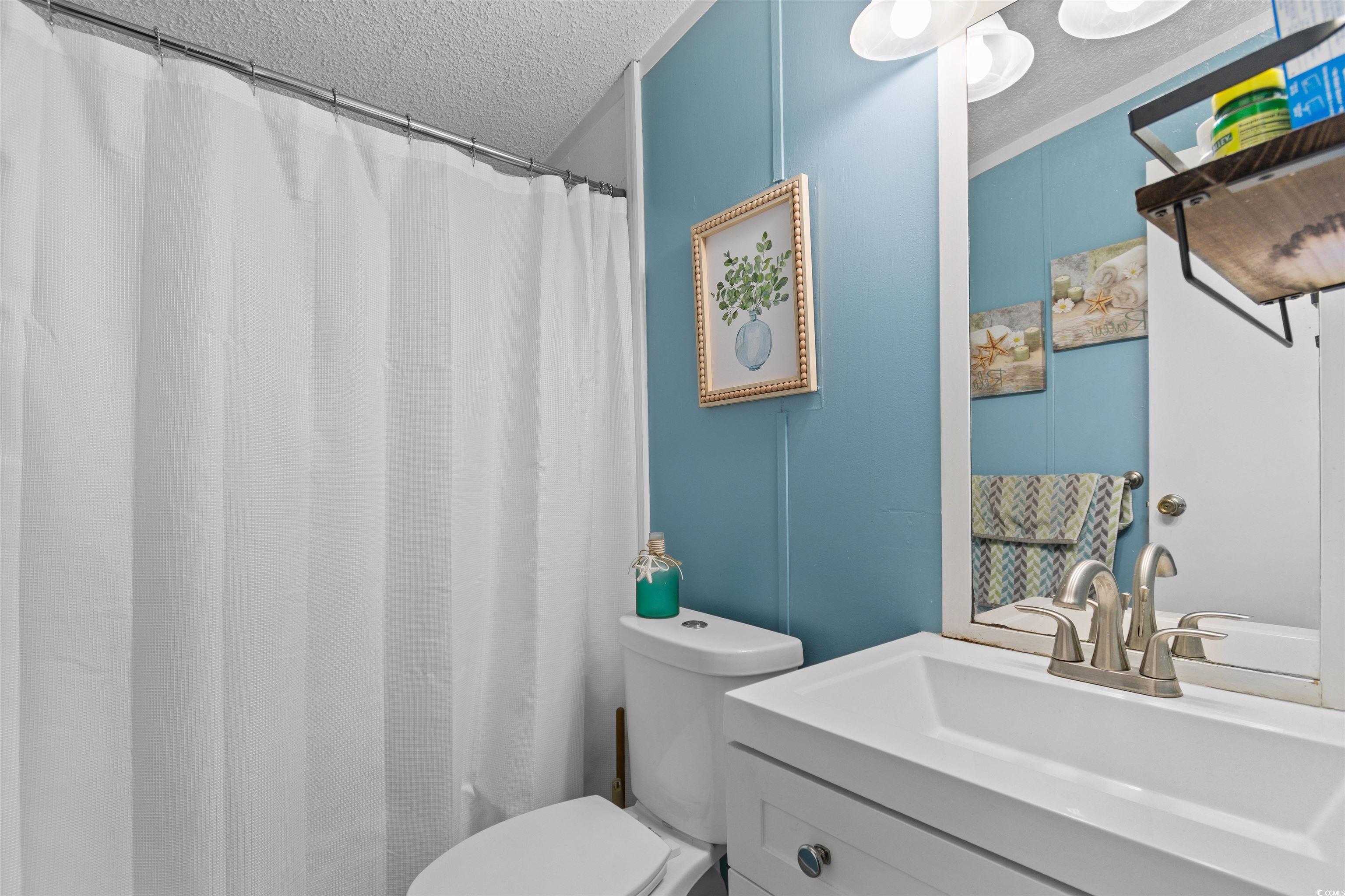 11140 Mcdowell Shortcut Road Murrells Inlet, SC 29576 - Photo 23 of 33 Full bath featuring a textured ceiling, vanity, and a shower with curtain