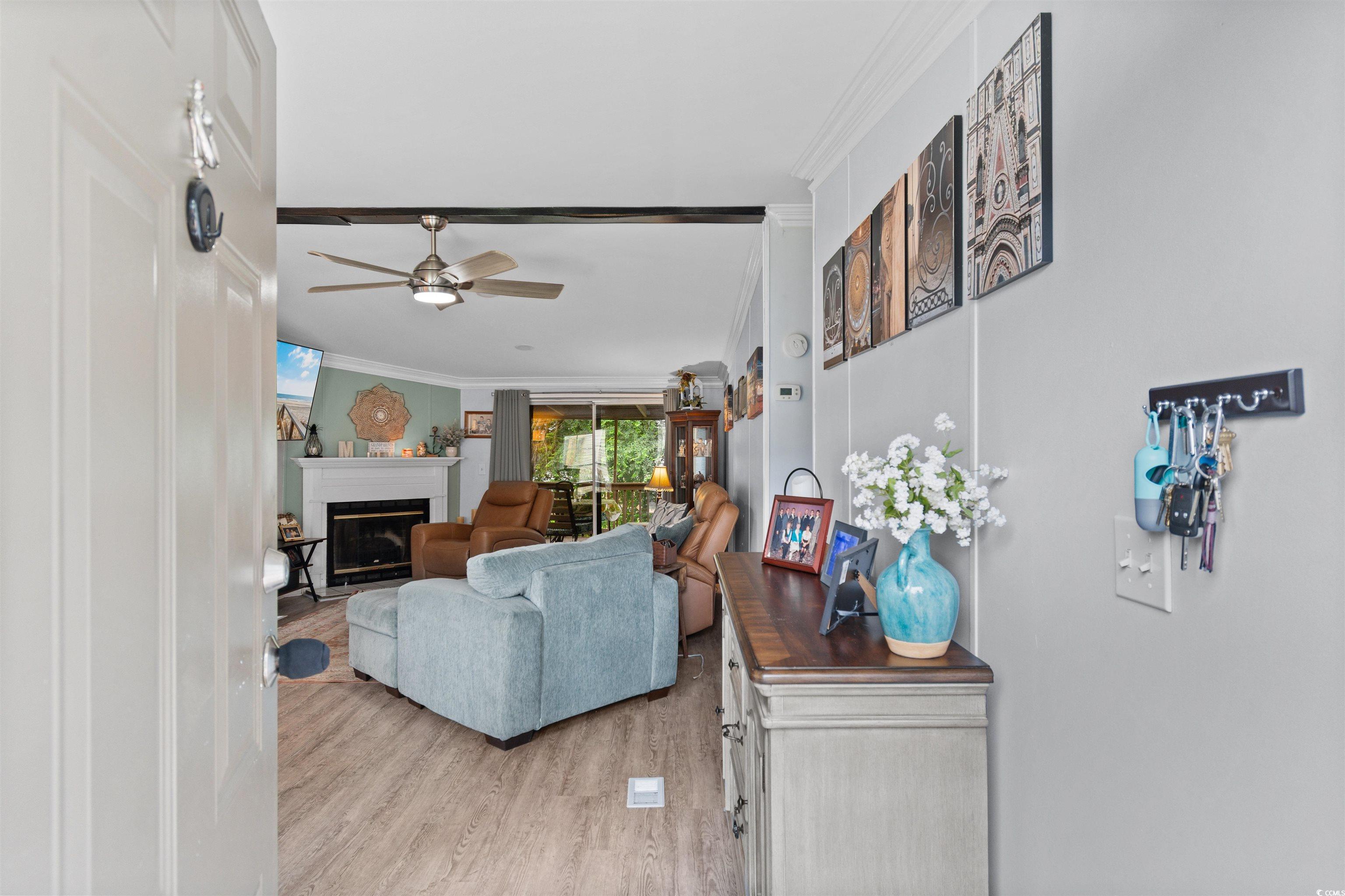 11140 Mcdowell Shortcut Road Murrells Inlet, SC 29576 - Photo 3 of 33 Living room with crown molding, light wood finished floors, a fireplace, and ceiling fan