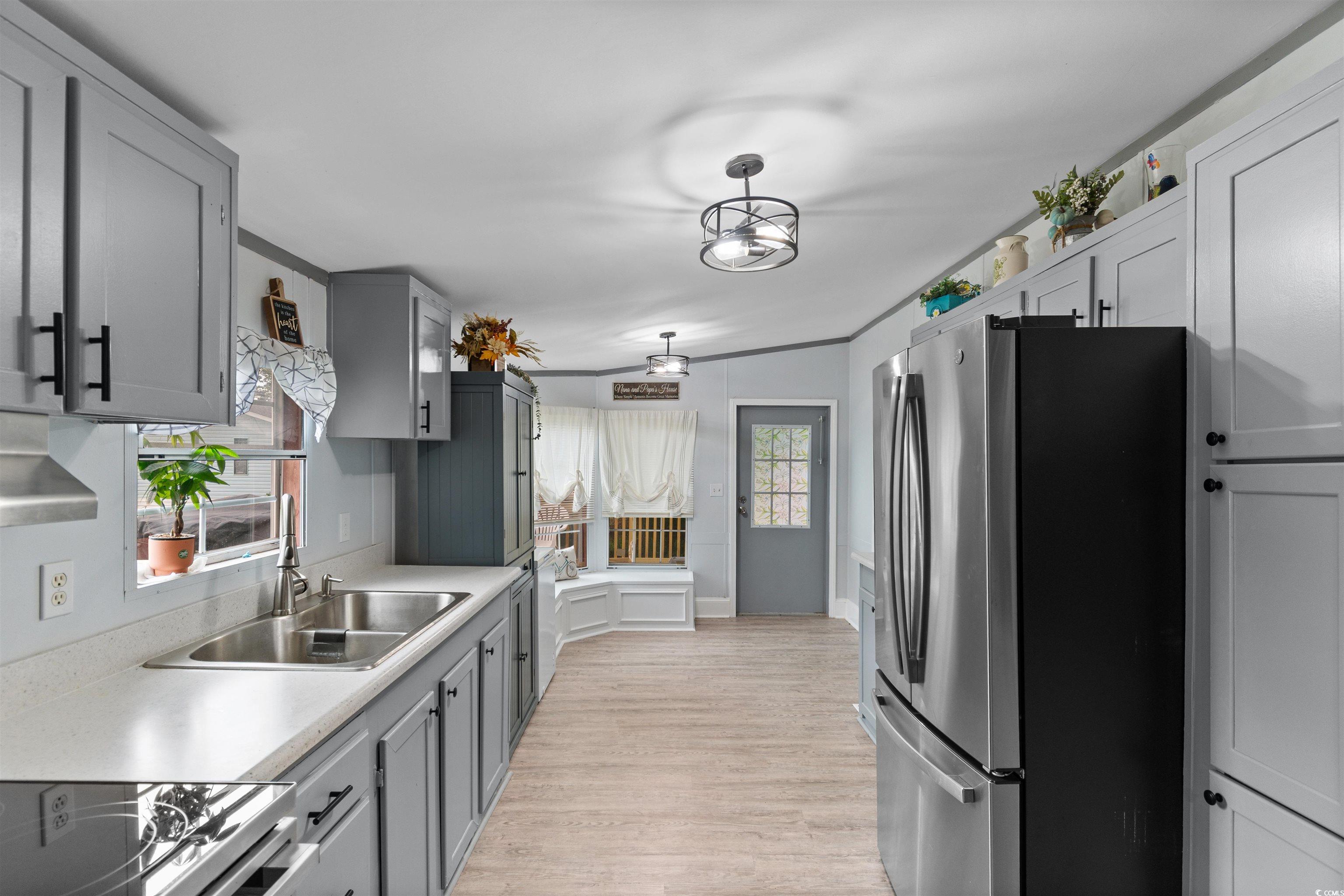 11140 Mcdowell Shortcut Road Murrells Inlet, SC 29576 - Photo 9 of 33 Kitchen with freestanding refrigerator, light wood-style flooring, lofted ceiling, light countertops, and gray cabinets
