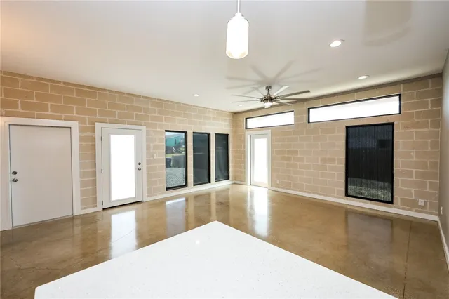 a view of an empty room with a window and fireplace