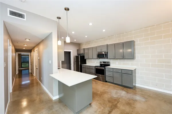 a large kitchen with kitchen island a sink stainless steel appliances and cabinets